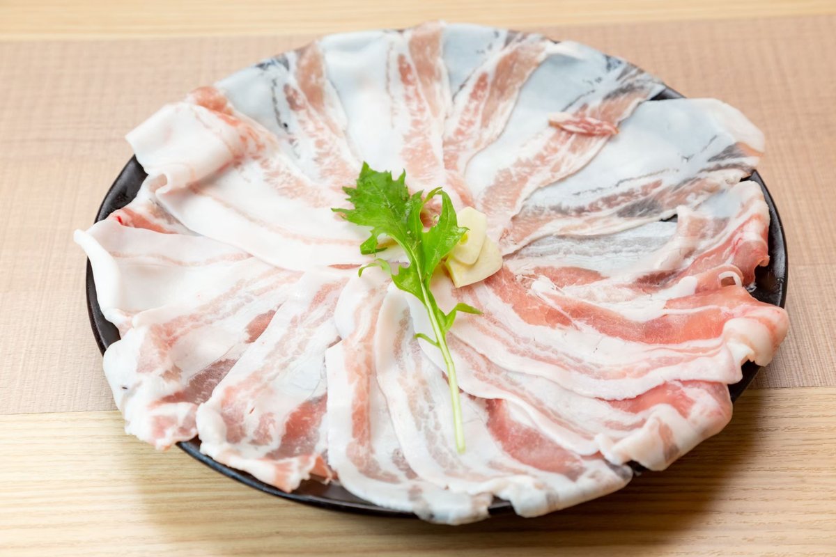薄く引かれた肉が、皿の上で花びらのように広がっています。